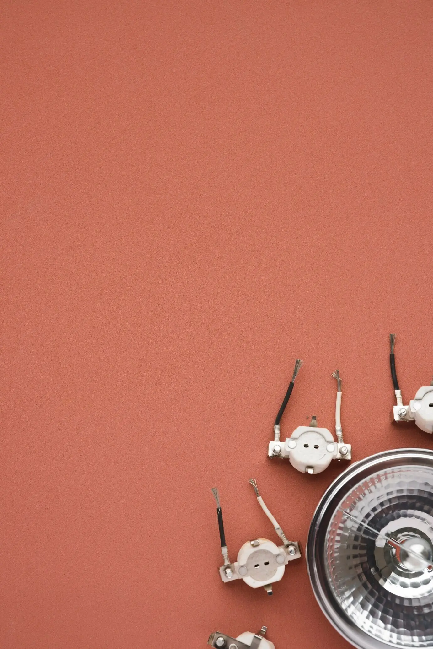 A spotlight and a socket in the corner of a brown background